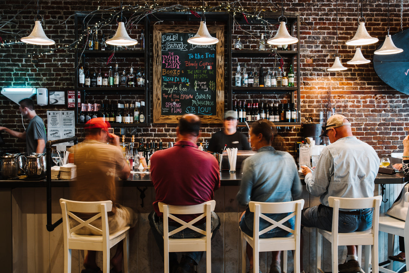 People sitting at the Bar enjoying themselves at Sweet Grass Dairy Cheese Shop. 
