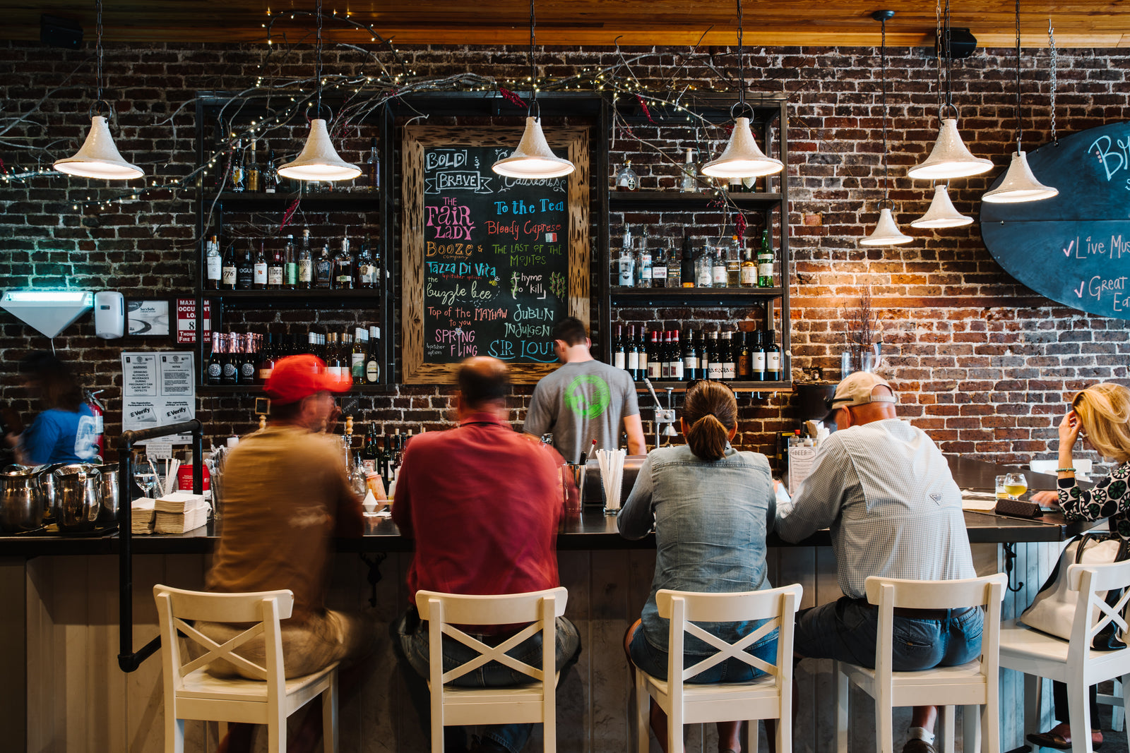 People sitting at a bar enjoying themselves at Sweet Grass Dairy Cheese Shop. 