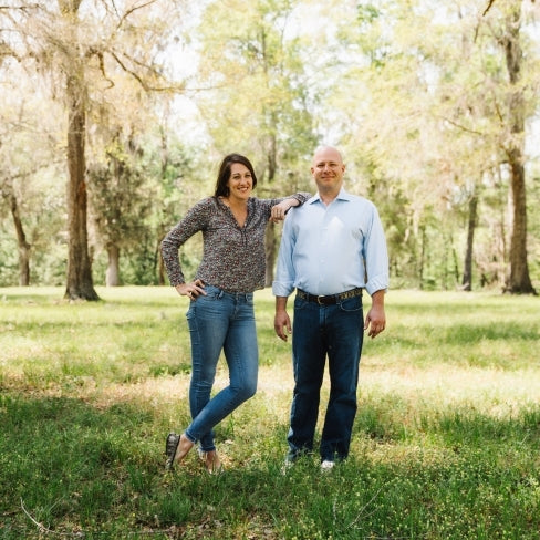 Owner Jessica & Jeremy Little posing in a field. 