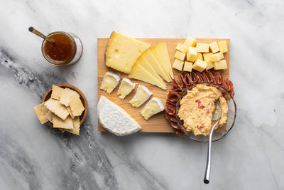 Cheese, Jam, Salami, and Crackers on a cheese board.