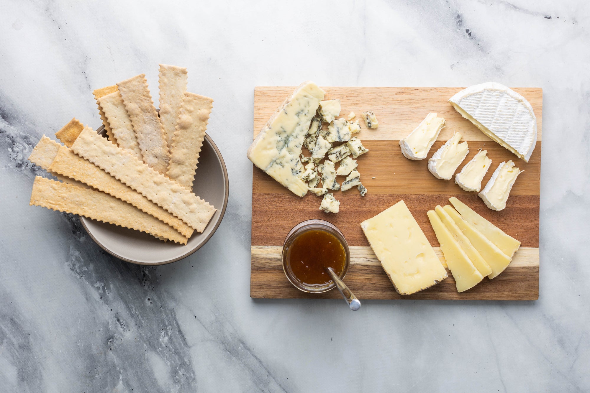Cheese, Jam, and Crackers on a cheese board. 