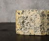 A piece of blue cheese that looks creamy and crumbly.