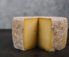 A wheel of cheese that is in the style of a Tomme.